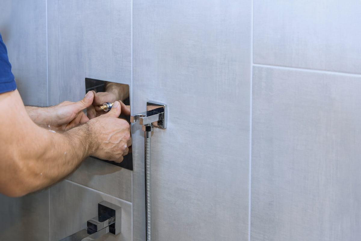 Instalación empotrada de grifo termostático en reforma de baño